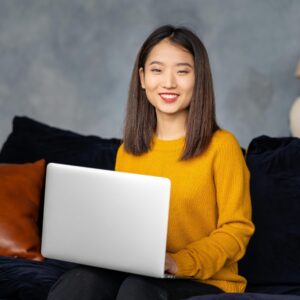 asian business woman working in laptop on sofa jap 4PNLNCB