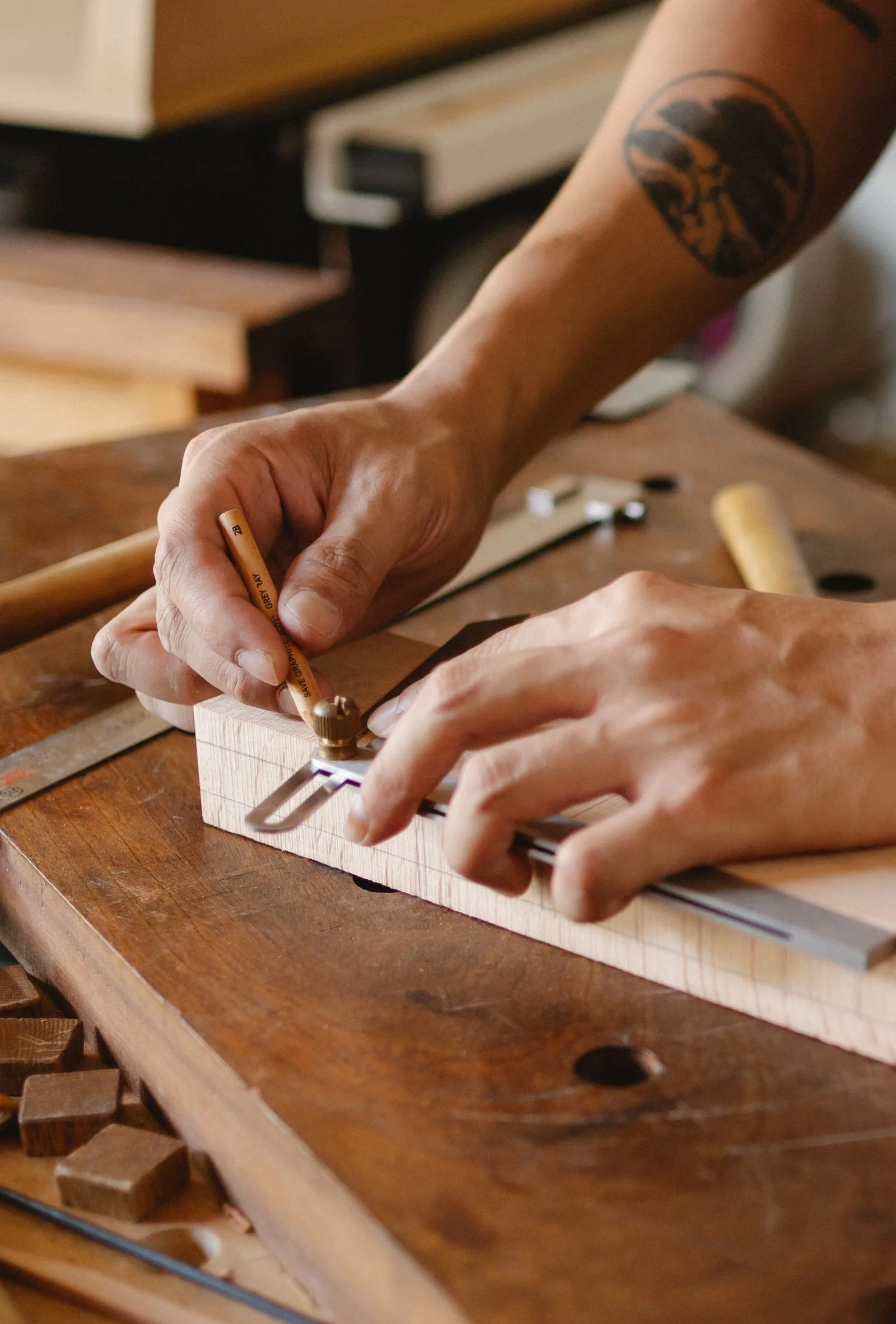 Craftsman measuring a piece of wood on a workbench