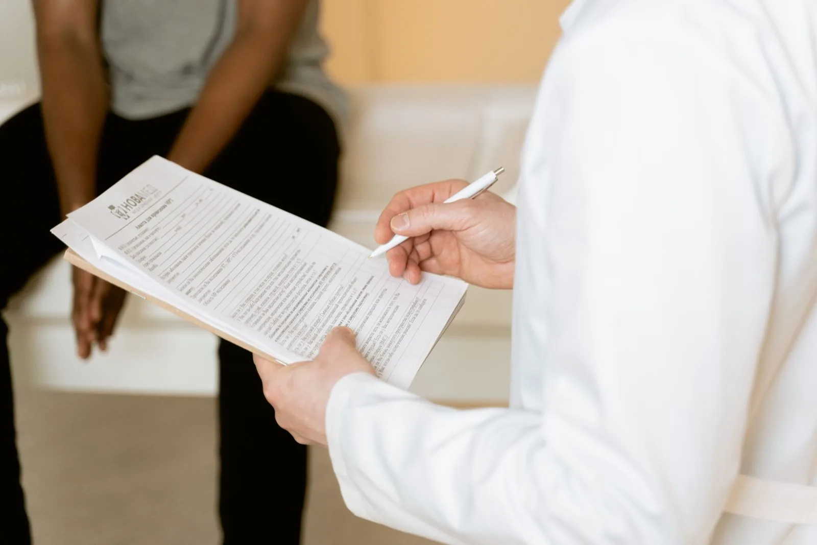 Healthcare professional reviewing a medical form during patient consultation