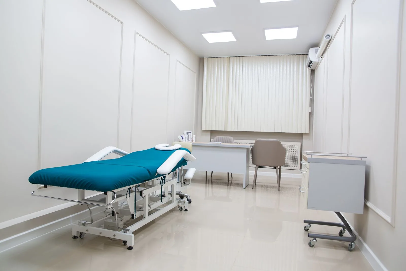 A contemporary medical office interior with modern furnishings and treatment bed