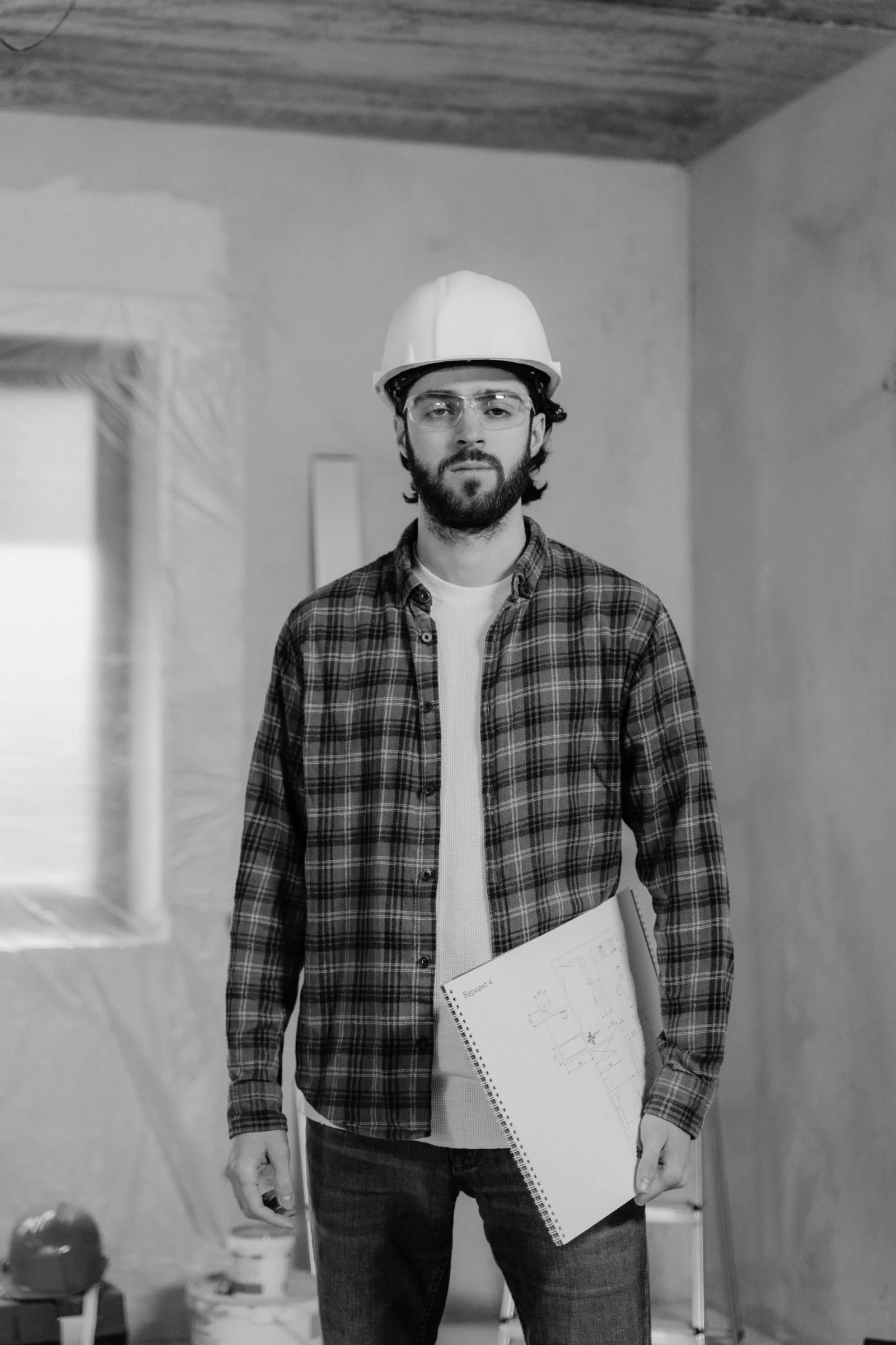 Contractor holding a blueprint inside a renovation site