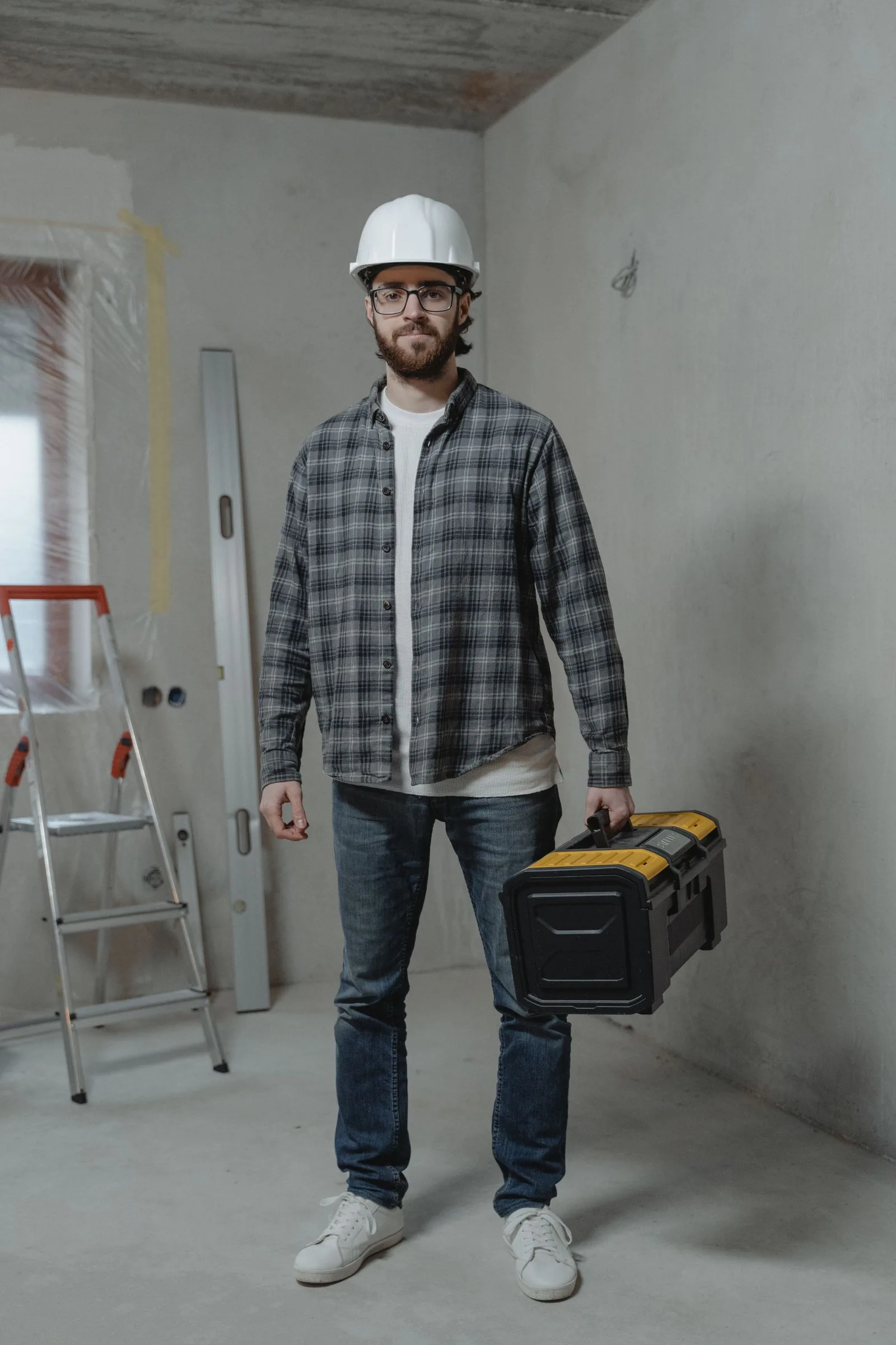 Contractor carrying a toolbox at a renovation site