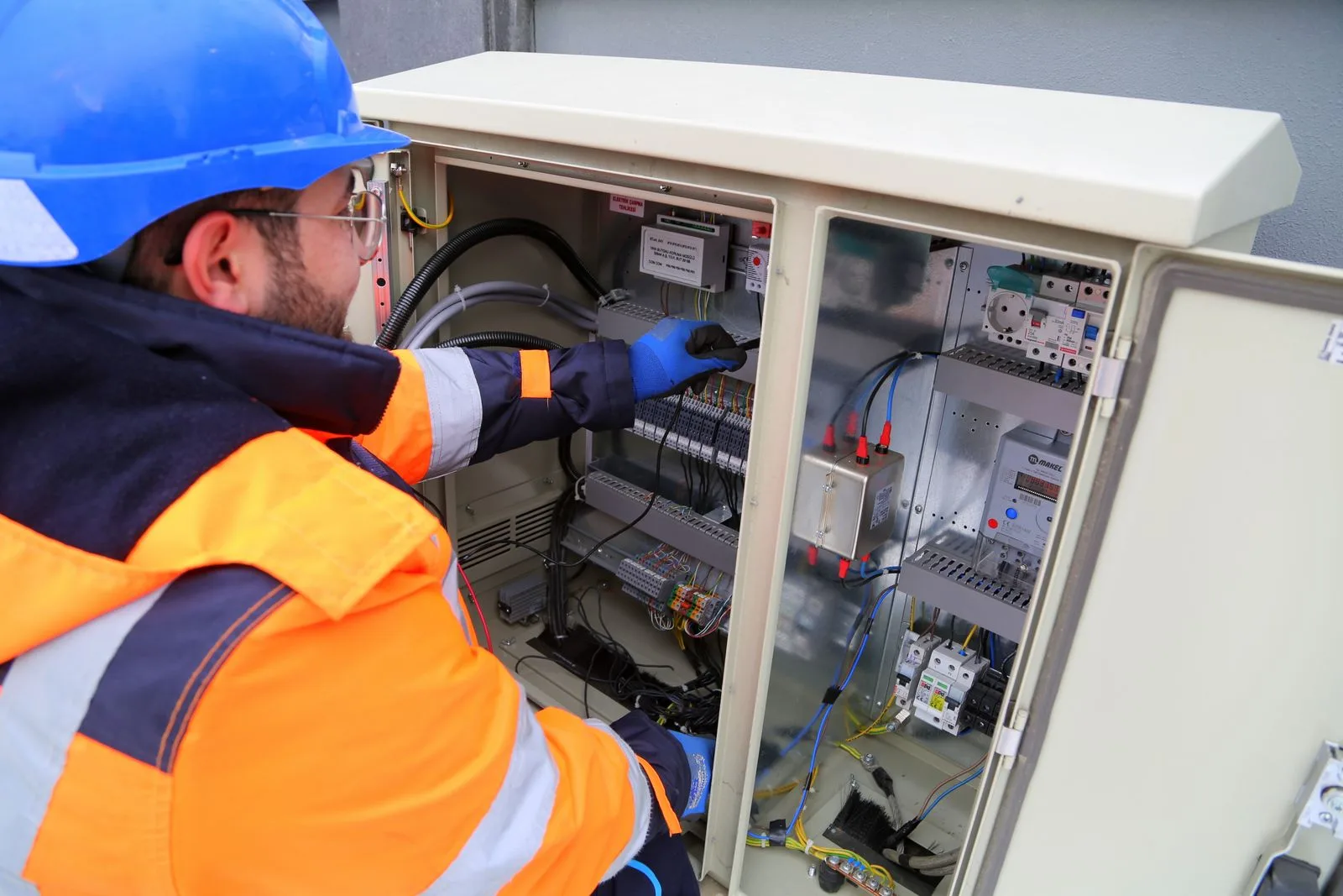 Electrician working on an outdoor electrical panel