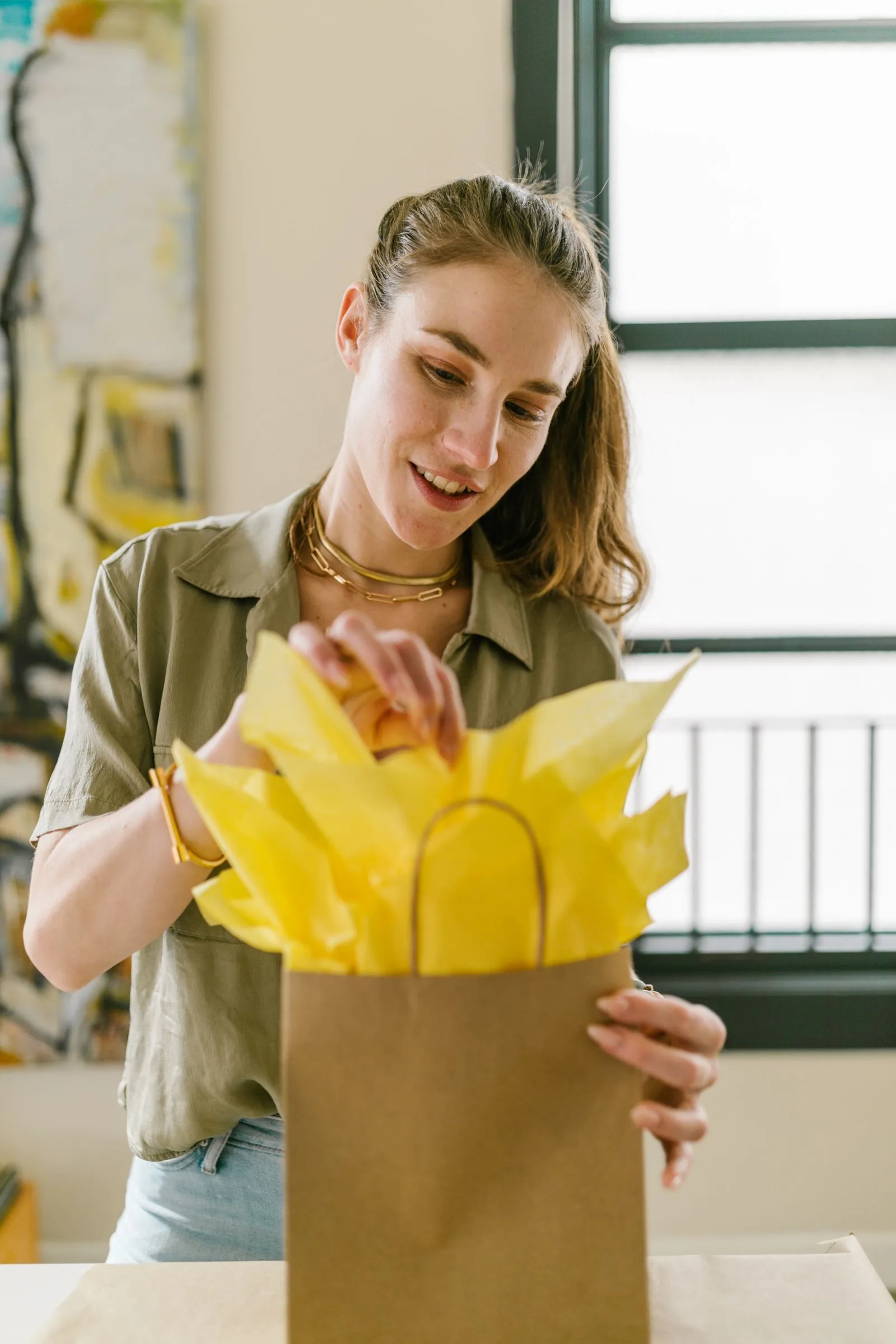 A craft business owner packing a gift order with tissue paper