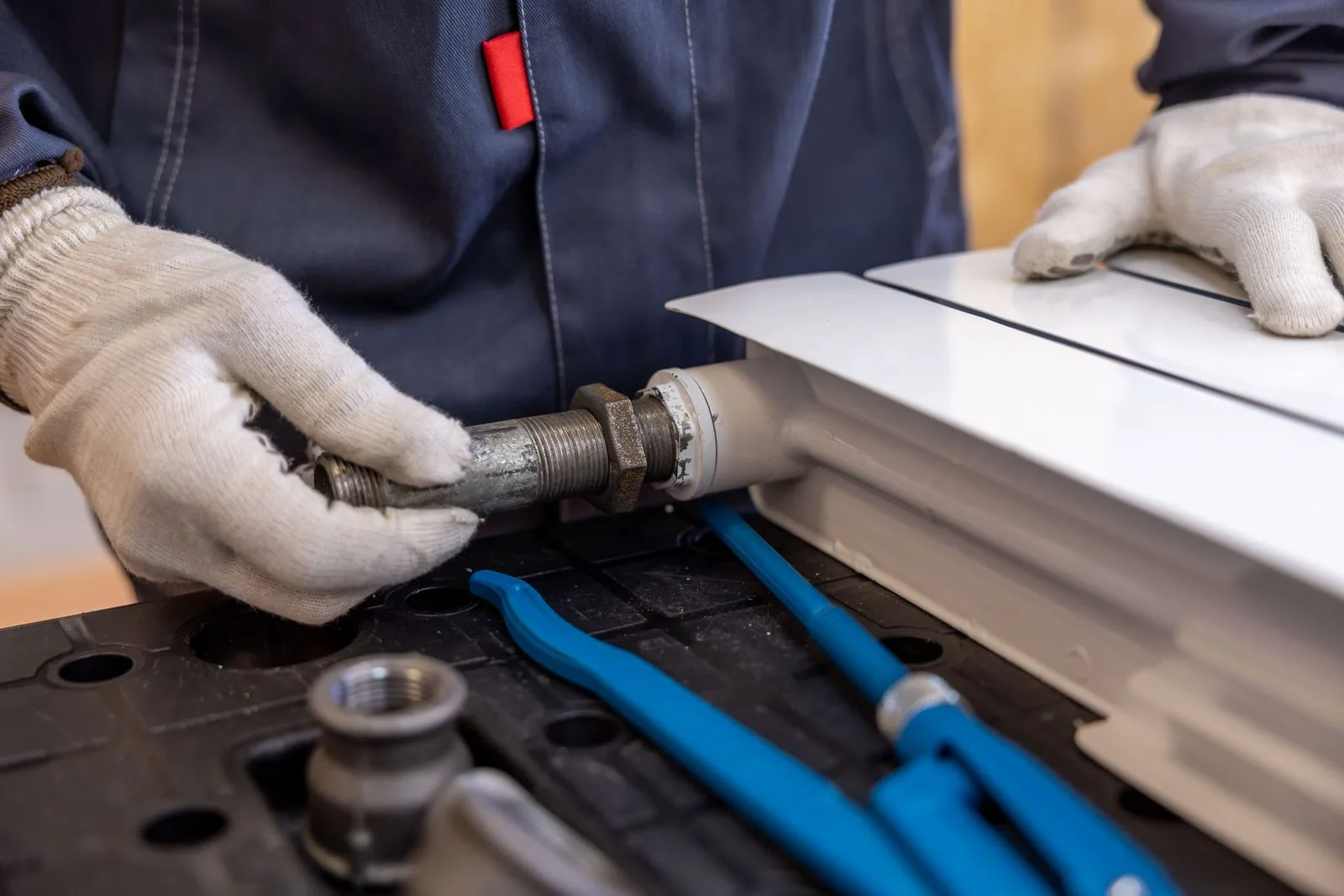 Plumber installing a radiator pipe