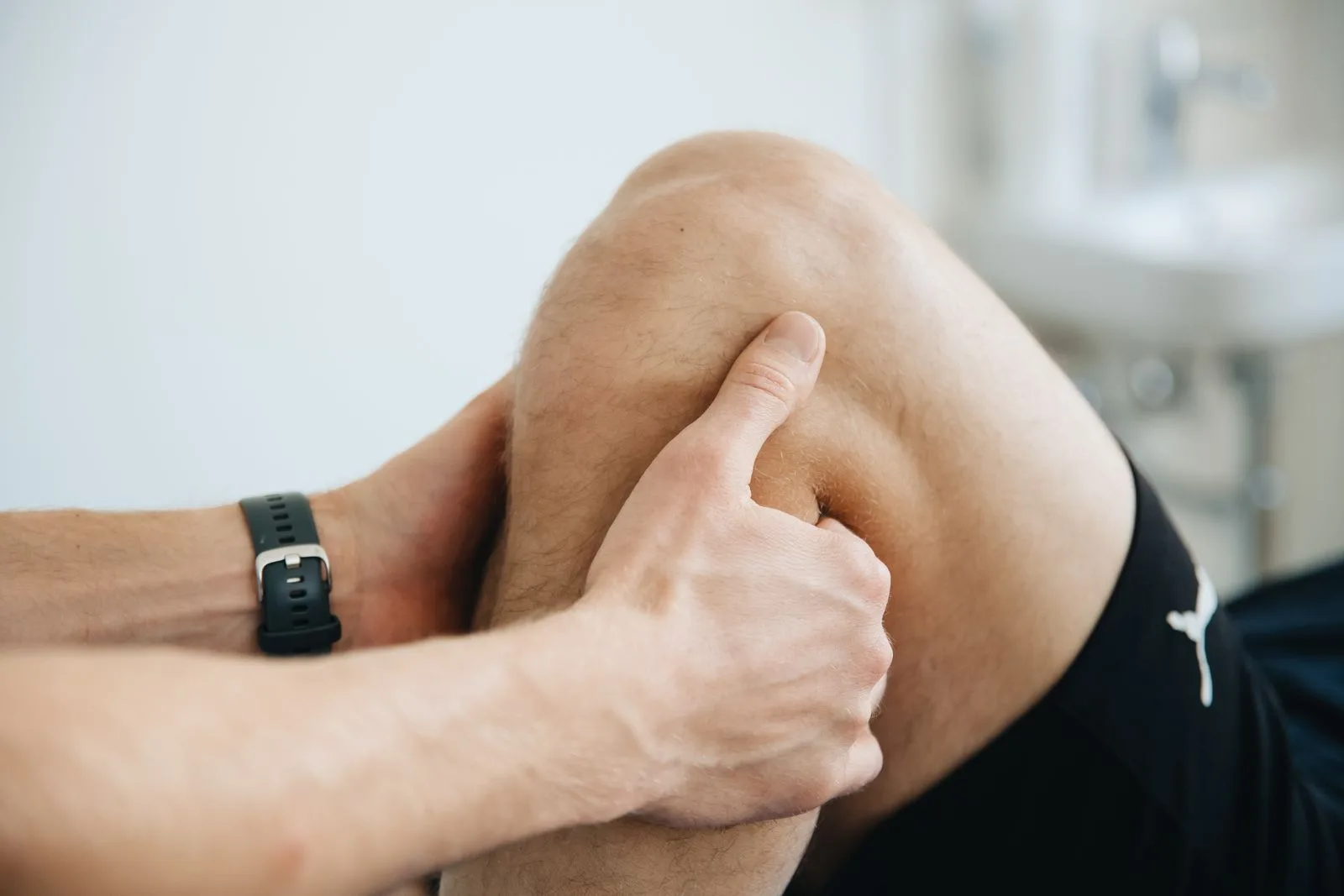 Physiotherapist massaging a patient knee during therapy